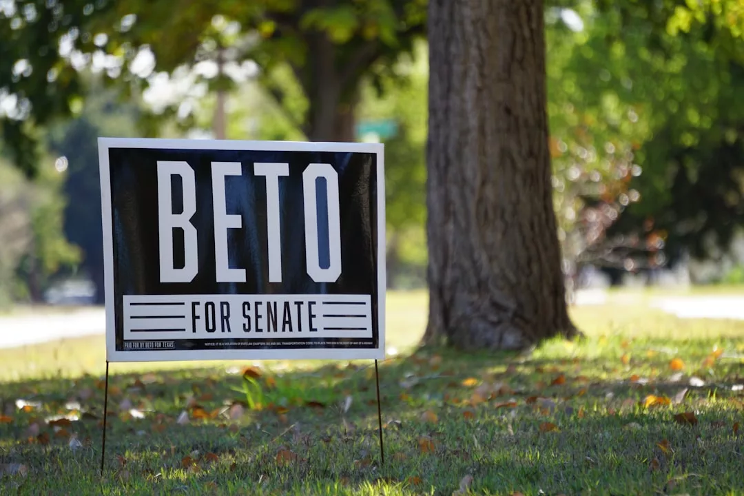 A campaign sign reading "Beto for Senate" is displayed on a grassy lawn near a tree, resembling the familiar look of real estate signs.
