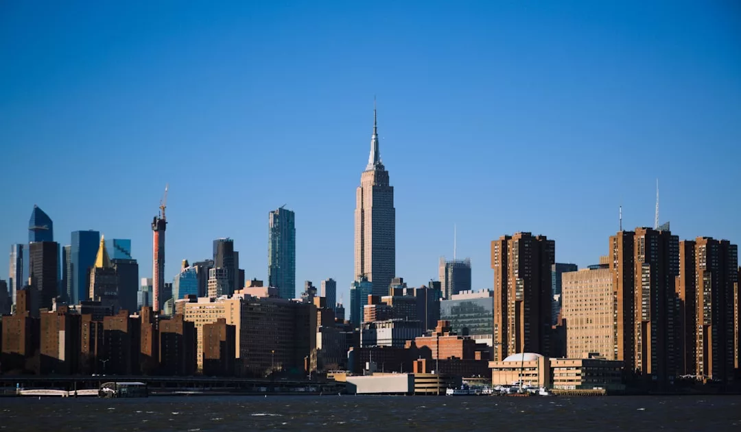 New York City skyline with the Empire State Building prominently visible, modern skyscrapers, and brick buildings under a clear blue sky highlight ongoing development projects similar to those planned in Stockholm for 2026.