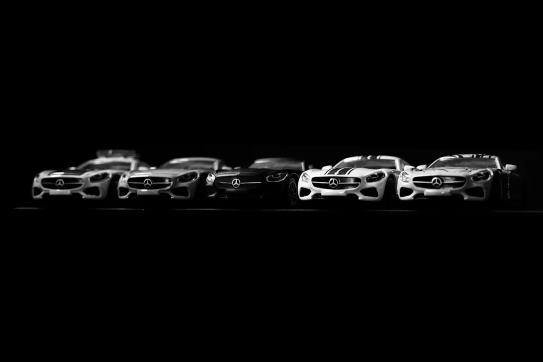 Six Mercedes-Benz sports cars in a row, displayed from left to right against a black background—an elite lineup where automotive luxury meets real estate elegance. The cars are white, black, and silver in varying shades.