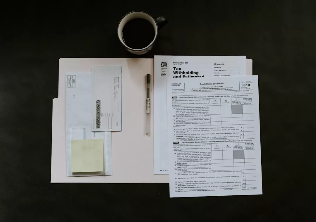 A folder with tax documents, a pen, envelopes, sticky notes, and a cup of coffee arranged on a dark surface—perfect for organizing real estate paperwork.