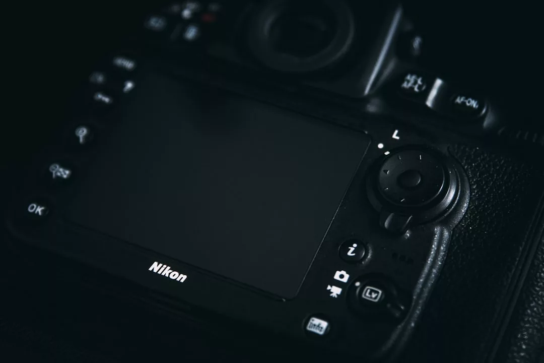 Close-up view of the back of a Nikon digital camera showing its screen, control buttons, and branding in low light—perfect for capturing stunning real estate photos.